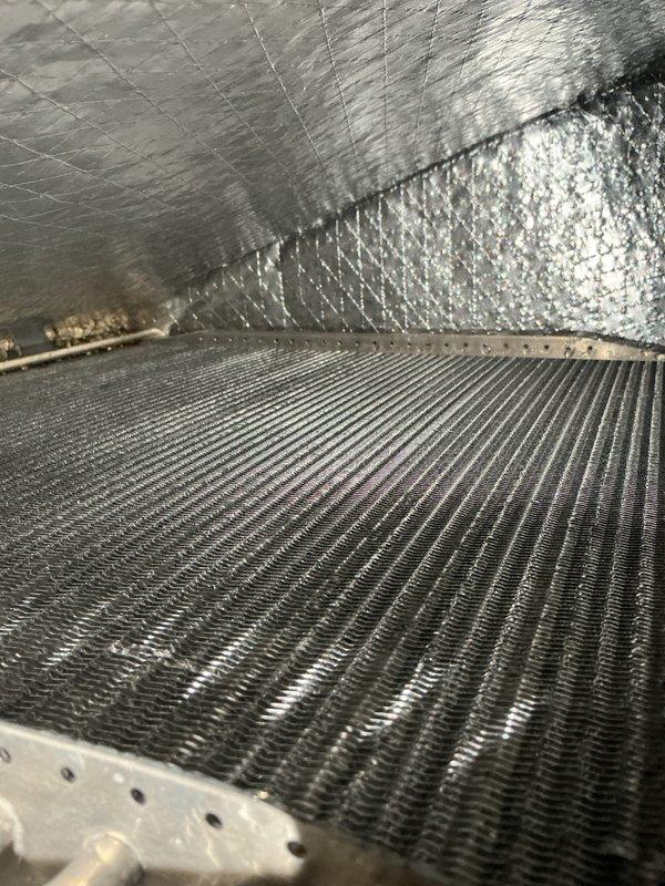 Completed CCC Basic Monthly Filter maintenance service on residential cooling system. Verified thermostat operation showing system actively cooling with setpoint at 72°F and proper display function. Inspected evaporator coil and surrounding air handler components, noting dust accumulation on coil fins and confirmed refrigerant lines intact with visible patina consistent with normal aging.
