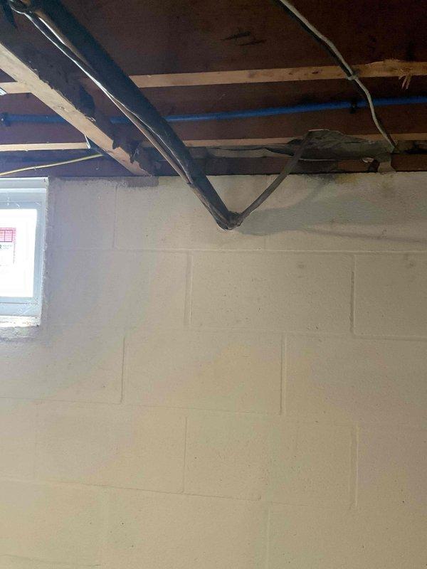 Conducted on-site evaluation of 30-year-old air conditioning system in residential basement location. Assessed existing cooling equipment, ductwork configuration, and installation conditions to provide comprehensive replacement estimate. Documented current system layout and structural considerations including exposed ceiling joists, existing duct routing, and available space for new equipment installation.