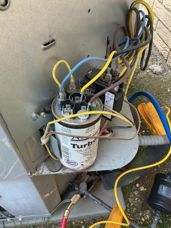 Performed comprehensive cooling system maintenance on residential HVAC unit under active comfort care agreement. Inspected outdoor condensing unit with exposed electrical components, including Turbo 200 capacitor with multiple wire connections; verified proper terminal connections and electrical integrity. Checked indoor Honeywell programmable thermostat displaying 73°F setpoint and confirmed proper system communication and control functions.