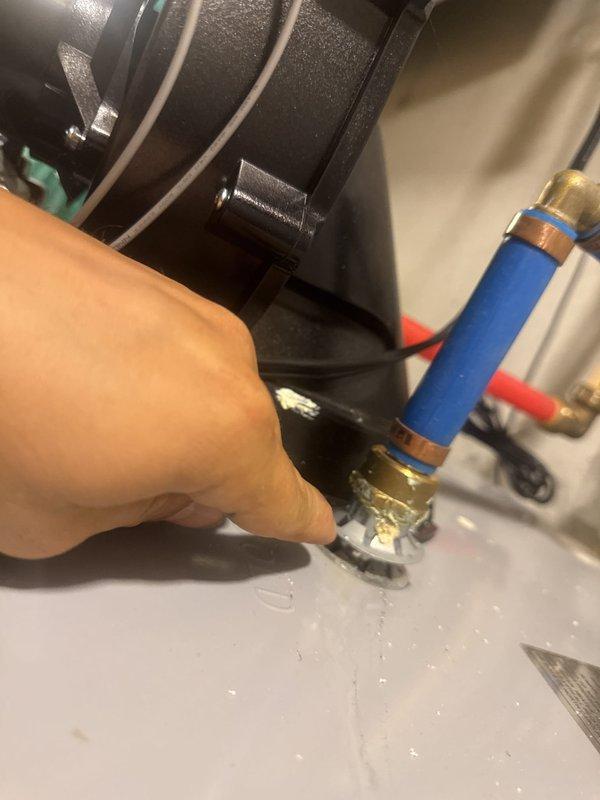 Responded to service call for water heater leak and discolored hot water throughout residence. Upon inspection, found water heater actively leaking despite previous flush attempt. Identified sediment buildup causing brown water discharge from all hot water faucets. Assessed water heater tank condition, circulator pump connections, and associated copper piping system. Inspected under-sink plumbing connections and brass fittings for additional leak points. Documented equipment condition including water heater labels, valve assemblies, and moisture accumulation. Recommended water heater replacement due to continued leaking and sediment contamination affecting water quality system-wide.