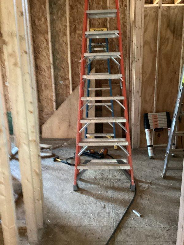 Completed electrical rough-in installation for new construction project, including installation and wiring of main electrical panel with circuit breakers and bus bar configuration. All rough-in work performed to code specifications with panel properly mounted between wall studs during framing phase, ready for insulation and drywall installation.