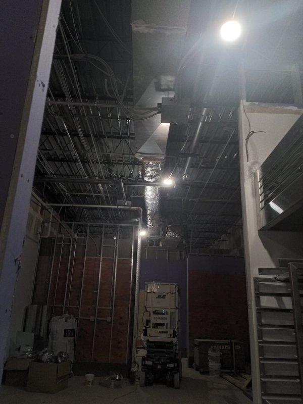 Completed final ductwork installation and insulation for commercial kitchen exhaust system. Installed and secured stainless steel ventilation hood with three exhaust ports, finished all associated ductwork runs throughout ceiling space, and applied metallic insulation wrap to main rectangular supply ducts to meet code requirements for the new construction rough-in phase.