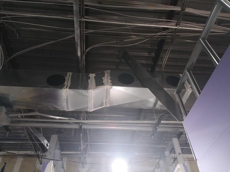 Completed final ductwork installation and insulation for commercial kitchen exhaust system. Installed and secured stainless steel ventilation hood with three exhaust ports, finished all associated ductwork runs throughout ceiling space, and applied metallic insulation wrap to main rectangular supply ducts to meet code requirements for the new construction rough-in phase.