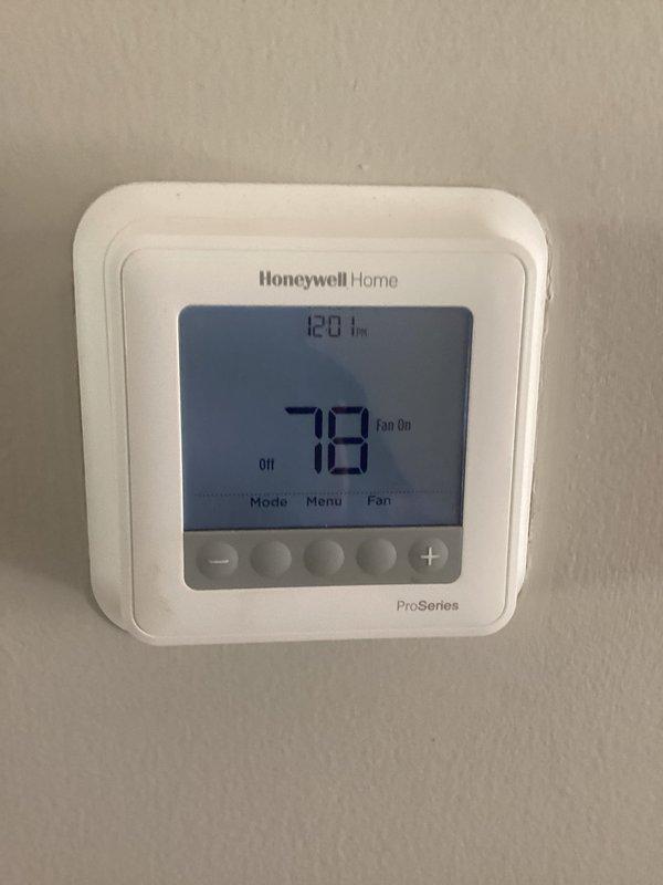 # HVAC Service Report

Responded to emergency service call for 2-year-old air conditioning system running but not cooling. Upon arrival, found Honeywell Home ProSeries thermostat displaying 78°F with system set to off and fan running continuously. Inspected outdoor condenser unit located on concrete pad with proper clearance from home's exterior. Unit appeared in good physical condition with clean coil fins visible through louvered panels and fan grille intact. Performed diagnostic testing to identify cooling failure. Determined root cause and completed necessary repairs to restore proper cooling operation. System tested and verified operational before departure.