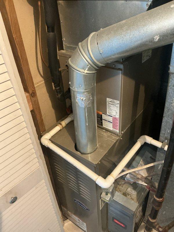 # HVAC Maintenance - Cooling System Service

Completed monthly basic cooling maintenance visit on residential HVAC system located in utility closet. System consists of vertically-stacked air handler with furnace unit, galvanized metal ductwork, and associated refrigerant lines with insulation.

## Work Performed

Conducted comprehensive visual inspection of cooling system components. Examined air handler and furnace unit for proper operation and physical condition. Inspected galvanized duct elbow connection, noting surface condensation present on exterior - consistent with normal system operation during cooling mode. Verified all manufacturer labels and technical specification stickers remain legible on furnace access panel.

Inspected white PVC condensate drain lines for proper drainage and secure connections. Verified multiple bends and routing configurations maintain proper pitch for condensate removal. Examined copper refrigerant lines with dark insulation wrapping for signs of dam