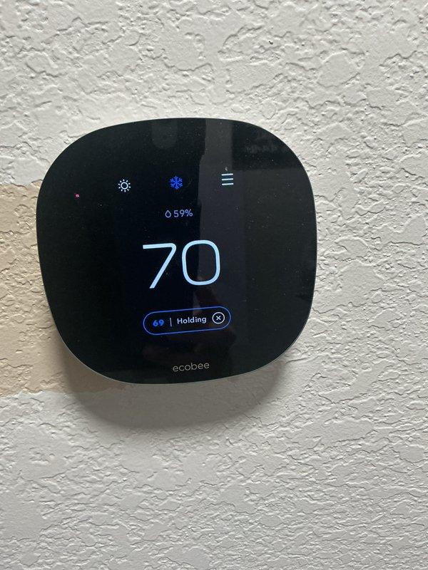Completed monthly preventive maintenance on residential cooling system. Performed standard CCHP protocol including inspection of outdoor condensing unit, verification of thermostat operation showing 70°F setpoint with 59% humidity reading on ecobee smart thermostat in hold mode. Accessed air handler interior to inspect electrical components, capacitor, and control board functionality. Verified all wire connections secure throughout complex wiring harness including power and control circuits. System operating within normal parameters at time of service completion.