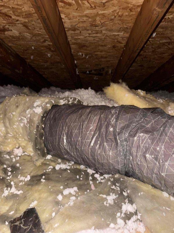 Crew scheduled to return to attic space to correct and replace hard pipe return ductwork. Visual inspection documented existing flexible duct installation with insulation coverage and identified areas requiring rigid return air duct modification to meet warranty specifications.
