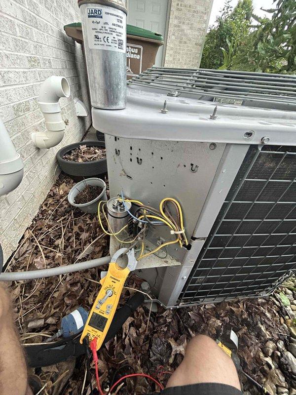 Responded to no cooling complaint on 9-year-old air conditioning system with outdoor fan not operating. Diagnosed failed dual run capacitor causing condenser fan motor failure. Replaced defective JARD capacitor with new unit, tested electrical connections with multimeter to verify proper voltage and amperage. Cleared debris accumulation from around outdoor unit, cycled system, and confirmed condenser fan motor operation and proper cooling restored.