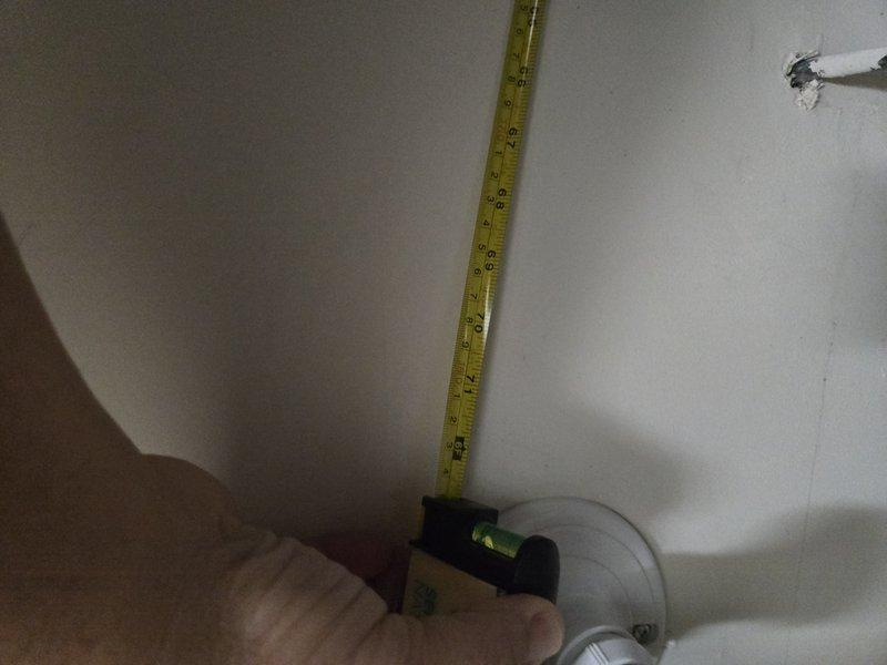 Conducted site visit to assess installation requirements for 40-gallon heat pump water heater. Measured available space dimensions in utility area to verify proper clearance for unit placement and documented existing plumbing connections including copper flex lines and shutoff valve configuration. Confirmed A.O. Smith water heater positioning and photographed installation area specifications for equipment compatibility verification.