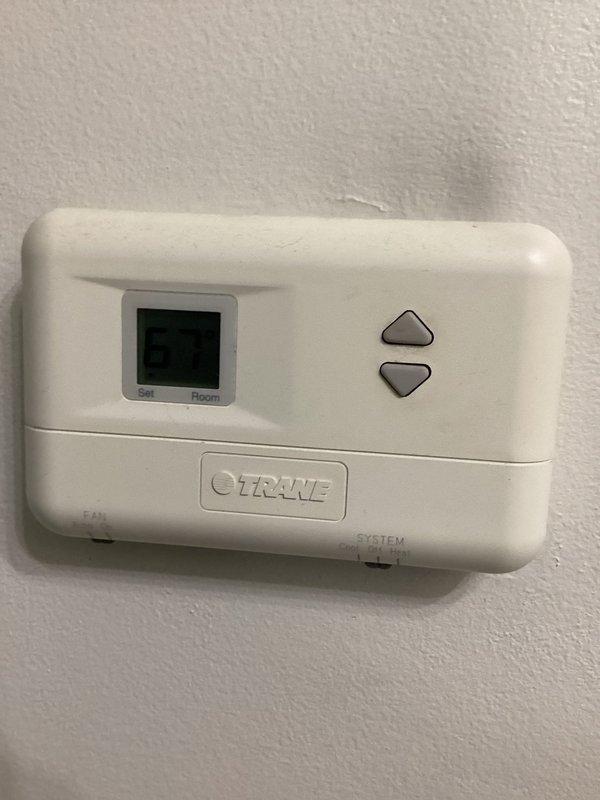 Responded to no cooling complaint on 20-25 year old AC system with indoor temperature stuck at 79°F. Upon arrival, inspected electrical panel and thermostat operation as customer reported previous burnt wire issue. Photographed electrical panel showing main breaker and circuit configuration, as well as Crane thermostat with digital display. Evaluated system electrical connections, breaker status, and thermostat functionality to diagnose cooling failure on aging outdoor unit.