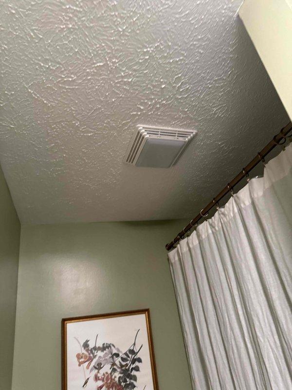 Completed bathroom ventilation system readjustment and warranty inspection. Accessed crawl space to reposition and secure flexible aluminum ductwork that had become compressed and displaced, restored proper insulation coverage around duct runs, and verified grille mounting and airflow at ceiling register. System tested and confirmed operating within manufacturer specifications.