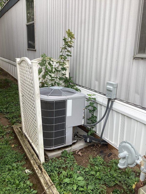 Completed monthly preventative maintenance on residential cooling system at manufactured home. Inspected outdoor condensing unit with lattice enclosure, verified refrigerant line connections and electrical disconnect box operation. Replaced 16x20x1 air filter at interior return air grille, checked airflow through ventilated door panel, and confirmed system operational parameters within manufacturer specifications.