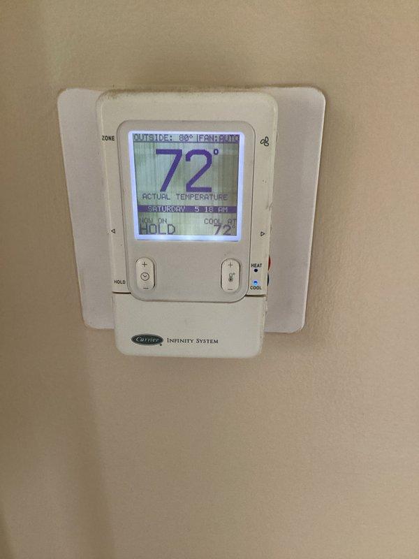 Performed comprehensive diagnostic evaluation of Carrier Infinity system for new homeowner experiencing multiple operational concerns. Identified critical issues including improper air intake configuration drawing exclusively from garage, missing air filter, inadequate duct sealing, existing humidifier kit requiring removal, compromised condensate drainage causing excessive moisture accumulation in equipment closet, and suspected black mold growth at base of air handler unit. Documented system conditions and deficiencies with photographic evidence showing thermostat operation and overall equipment installation. Provided assessment of necessary corrective actions including ductwork modifications, condensate drain repair, mold remediation requirements, and proper air filtration installation to restore system to safe and efficient operation.
