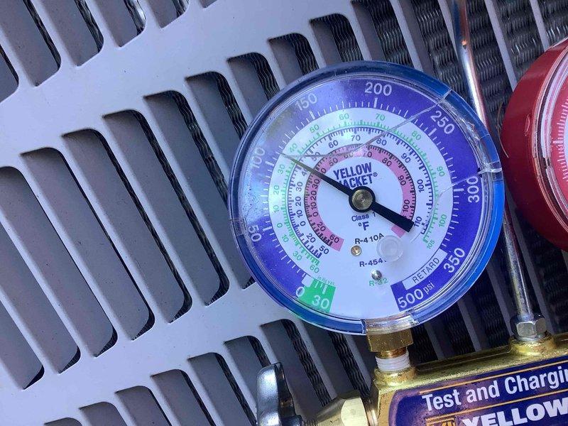 Responded to service call for upstairs air conditioning unit with full drain pan identified during home inspection. Performed diagnostic evaluation of condensate drainage system and tested refrigerant pressures using manifold gauges on R-410A system. Cleared drain line obstruction, verified proper condensate flow, and confirmed unit operational with adequate cooling capacity.