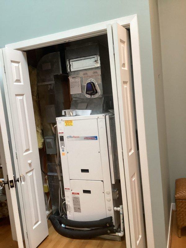 Responded to moisture concern related to HVAC system in closet. Upon inspection, found vertical water streaking pattern on adjacent wall surface originating from upper portion of unit. Verified air conditioning system operating within normal parameters with no signs of condensation, perspiration, or elevated humidity levels in closet space. Confirmed no excess heat generation from equipment. Documented conditions with photographs showing wall discoloration pattern and installed HVAC unit configuration. Staining pattern appeared inconsistent with typical HVAC-related moisture issues, suggesting alternative water source from above unit rather than condensate or refrigerant system malfunction.