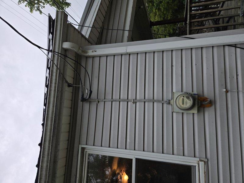 Completed residential electrical panel upgrade with installation of new exterior meter base and service disconnect. Removed obsolete knob and tube wiring from interior circuits and replaced with modern NM cable to meet current electrical code requirements. Upgraded main service entrance conductors and installed new weatherhead assembly on exterior corrugated metal siding, ensuring proper clearances and secure mounting. Interior work included removal of deteriorated wall sections to access and eliminate knob and tube wiring, replacement of affected branch circuits, and installation of new distribution panel with appropriate circuit protection. All connections tested and verified operational upon completion.