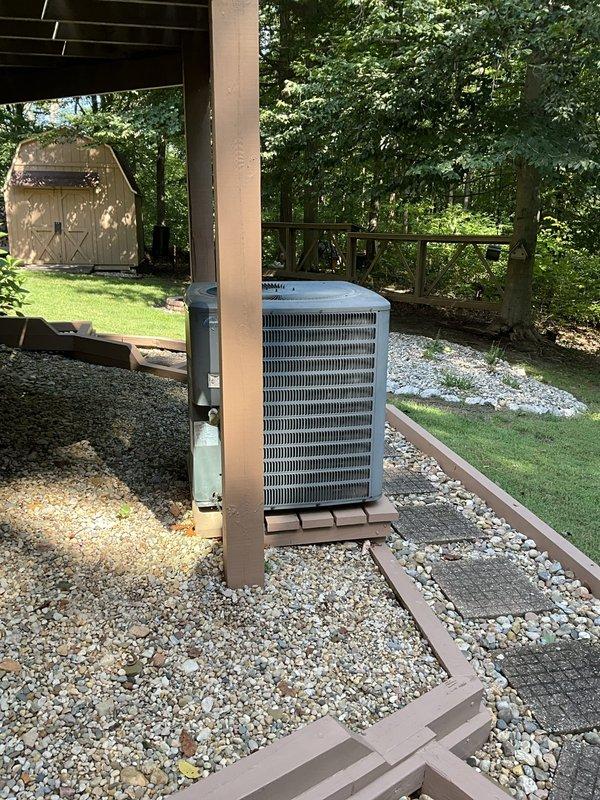 Completed comprehensive estimate for full HVAC system replacement with GOODMAN equipment at residential property. Assessed existing outdoor condenser unit currently installed beneath deck structure on gravel pad, evaluated electrical routing along deck beams, and documented site conditions including accessibility and clearance requirements for new equipment installation.