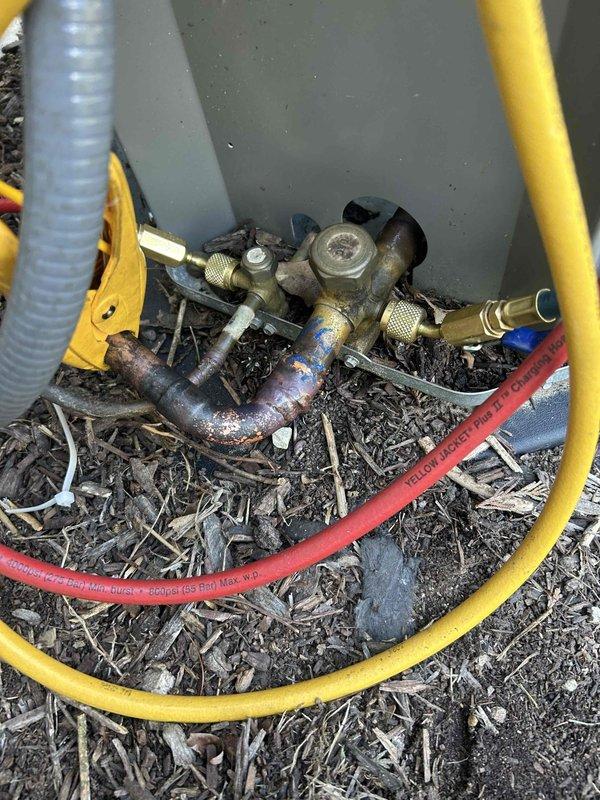 Responded to service call for residential air conditioning system with refrigerant leak. Located leak at severely corroded service valve assembly on outdoor condenser unit. Repaired leak at valve connection point, evacuated system to remove air and moisture, and recharged unit to manufacturer specifications using manifold gauge set to verify proper refrigerant levels and system pressures.