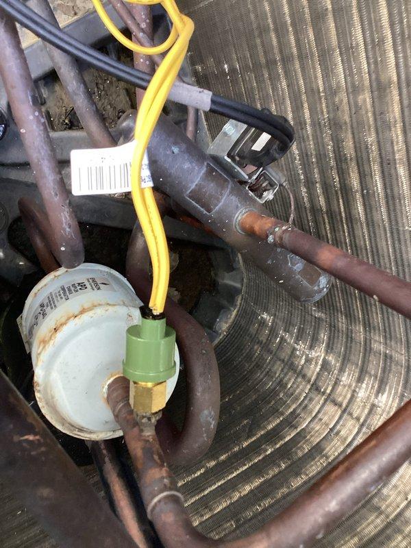Replaced faulty high pressure switch on residential air conditioning system. Disconnected refrigerant lines, removed defective switch, installed new component, and reconnected all electrical connections to restore proper system operation and safety controls.