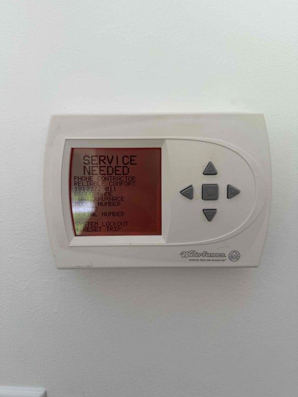 Responded to callback for GEOLINK geothermal system displaying "SERVICE NEEDED" and "SYSTEM LOCKOUT" error on thermostat. Upon inspection, identified fault condition triggering safety lockout on ground loop control unit. Cleared error codes, verified ground loop circulation pump operation, checked refrigerant line connections and insulation integrity on all four ground loop pipes. Reset system lockout at thermostat, confirmed proper communication between control unit and thermostat, and verified system returned to normal heating/cooling operation without further fault codes.