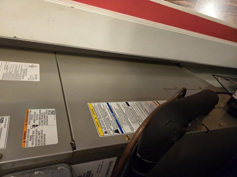 Responded to service call for air conditioning unit with reported water leak suspected to be from drain pan. Upon arrival, met with property contact and inspected the indoor air handler unit. Found evidence of water leakage at ceiling level near the HVAC equipment installation. Examined the air handler cabinet and surrounding area, documenting conditions with photographs. Visually inspected the condensate drain pan, drain line connections, and refrigerant lines for signs of moisture or active leaking. Unit appeared to have previous history of drain pan issues based on service notes.