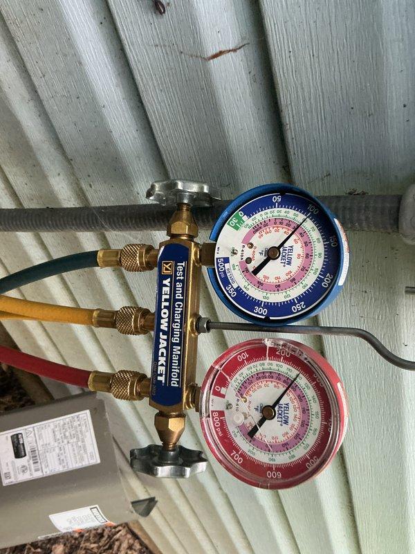Completed annual cooling system maintenance visit. Performed comprehensive system inspection including refrigerant pressure testing using manifold gauges, verified proper operating pressures on both high and low sides. Thermostat functioning correctly, displaying 72° current temperature with system set to cool to 69°, operating in cooling mode as designed. All equipment operating within normal parameters.