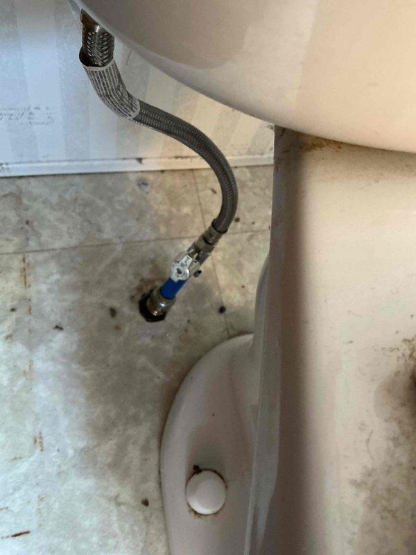Responded to emergency call for bathroom flooding caused by failed toilet supply line. Upon arrival, found water supply shut off to entire house and significant water damage to bathroom floor with visible staining and saturation of linoleum flooring. Inspected toilet connections and identified deteriorated flexible braided supply line as source of leak. Replaced faulty supply line with new braided stainless steel connector, installed proper shutoff valve, and tested all connections for leaks. Restored water service to house and verified proper operation of toilet fill valve and supply system with no further leakage detected.