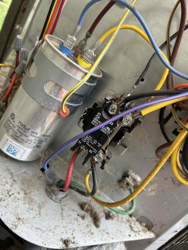 Responded to service call for wireless thermostat displaying error message and unable to connect to outdoor condensing unit. Inspected outdoor unit and found aged equipment with weathered components and accumulated debris on cabinet and coil surfaces. Examined electrical panel containing capacitor and contactor assembly, verified wire connections at terminals, and tested communication pathway between thermostat and control board. Troubleshot wireless connectivity issue, reset communication protocol, and restored proper connection between thermostat and HVAC system. System now operating normally with thermostat communicating successfully with condensing unit.