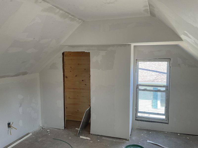 Conducted site evaluation for air conditioning addition to existing heating system and assessed unfinished attic space for potential ductless mini-split installation. Documented electrical panel capacity with available circuits and photographed upstairs area showing construction-ready conditions with adequate access for future HVAC equipment placement.