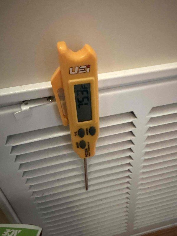 Completed routine HVAC maintenance under active CCC basic coverage agreement. Measured supply air temperature at 75°F using digital thermometer at return air grille, accessed and inspected 12x12x1 air filter through hinged return register, and documented system conditions with photos showing proper airflow measurements and filter access point.