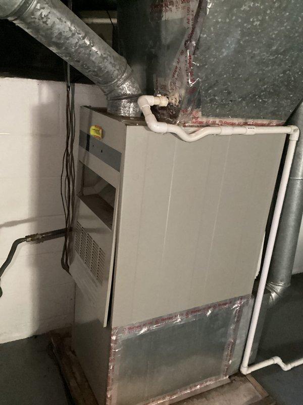 Responded to customer inquiry regarding HVAC system operation and thermostat functionality. Inspected residential heating system including digital programmable thermostat currently set at 70°F and basement-mounted furnace with associated ductwork, condensate drain lines, and electrical connections. Documented system configuration with photos showing thermostat display and complete furnace installation including flexible and rigid ductwork, PVC drainage piping, and proper electrical wiring. Addressed customer questions about system operation and provided technical guidance on equipment functionality.
