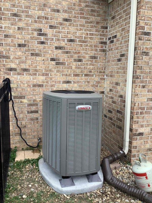 Completed full installation of Lennox heat pump system including indoor air handler unit positioned in utility closet and outdoor condensing unit installed on composite pad in exterior corner location. Indoor unit features proper PVC condensate drainage and venting configuration with all manufacturer labels and technical specifications clearly visible, while outdoor condenser is professionally positioned on gravel base with electrical conduit and refrigerant line set connections completed per manufacturer specifications.