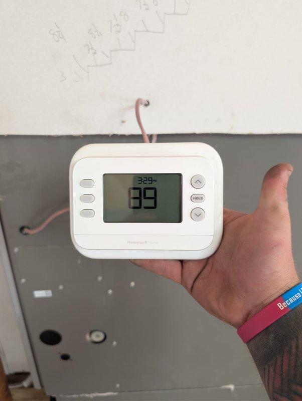 Completed full system installation of Lennox air conditioning condenser unit and evaporator coil in downflow configuration. Positioned outdoor condenser on concrete pad adjacent to structure, secured refrigerant lines and electrical conduit to exterior wall with proper routing through disconnect box, and installed evaporator coil in downflow orientation within indoor air handler. Installed Honeywell Home digital programmable thermostat for system control, completed all refrigerant line connections, performed system startup and verification of proper operation.
