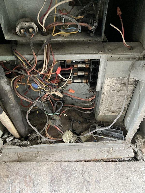 Conducted on-site evaluation of 1992 heat pump system previously diagnosed as failed by another contractor. Accessed unit through rear gate using provided entry code while homeowner was out of state for work. Inspected internal electrical compartment revealing aged wiring, discolored connections, and accumulated debris consistent with 30+ year-old equipment. Documented existing electrical panel and compromised heat pump components. Provided comprehensive photographic documentation of deteriorated wiring harnesses, terminal connections, and overall system condition to support replacement recommendation for antiquated HVAC equipment that has exceeded its serviceable lifespan.