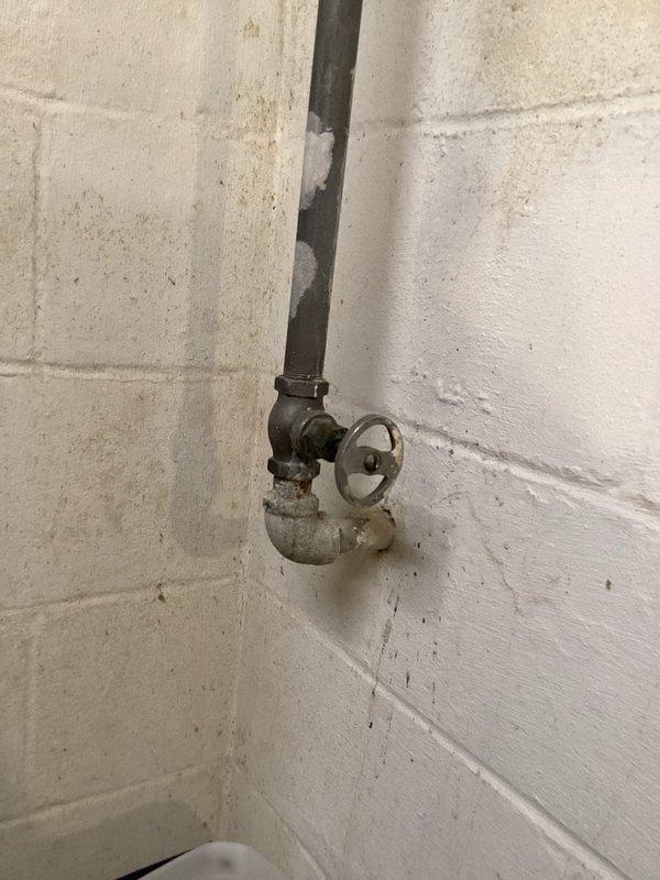 Provided estimate for replacement of existing shut-off valve on vertical supply line in basement utility area. Valve assembly shows significant age and corrosion, with deteriorated galvanized piping below the valve exhibiting chalky surface oxidation. Recommended full valve replacement to ensure reliable water control and prevent potential failure of aging components.