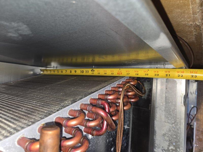 Responded to emergency no-cooling call and performed system diagnostics on air conditioning unit of unknown age. Upon inspection, measured evaporator coil dimensions and assessed copper tubing configuration and heat exchanger condition to determine system specifications and identify cause of cooling failure. Documented equipment measurements and component layout for service records.