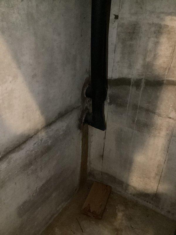 Responded to service call for reported water leakage around geothermal unit. Upon inspection, documented significant water staining and moisture damage on concrete floor and walls in utility area surrounding the geo system, with concentrated pooling patterns in corner near equipment. Photographed affected areas showing extent of water infiltration and surface discoloration for diagnostic purposes and customer records.