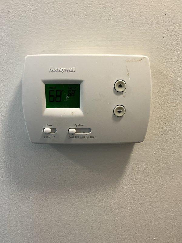 Completed monthly heating maintenance visit on residential HVAC system. Inspected Honeywell digital thermostat confirming proper operation with system set to heat mode at 69 degrees. Accessed air handler unit and visually inspected evaporator coil, noting dust and dirt accumulation on coil surfaces requiring future cleaning attention. Observed degraded insulation material around drainage connections and general wear consistent with system age. Filter size could not be determined during this visit. System operational at time of departure.