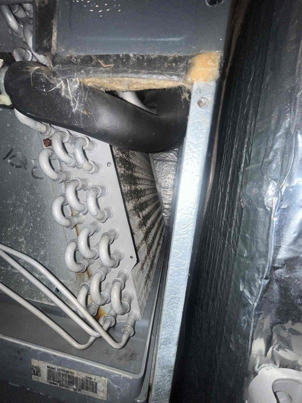 Completed monthly heating maintenance visit on residential HVAC system. Inspected Honeywell digital thermostat confirming proper operation with system set to heat mode at 69 degrees. Accessed air handler unit and visually inspected evaporator coil, noting dust and dirt accumulation on coil surfaces requiring future cleaning attention. Observed degraded insulation material around drainage connections and general wear consistent with system age. Filter size could not be determined during this visit. System operational at time of departure.