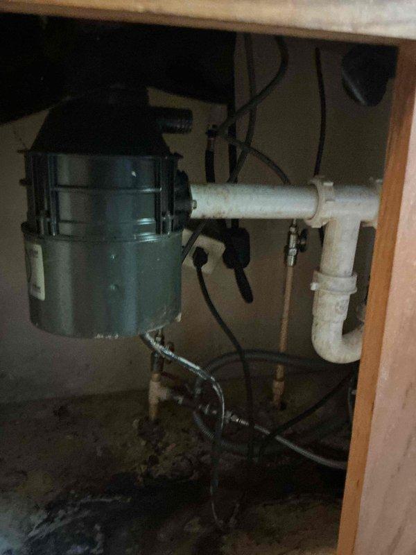Conducted on-site assessment for garbage disposal replacement under kitchen sink. Inspected existing installation including mounting hardware, electrical connections, and PVC drain line configuration. Evaluated cabinet space clearance, trap assembly, and discharge plumbing to determine compatibility with new unit. Documented current disposal unit condition and surrounding plumbing infrastructure. Provided estimate for removal of existing disposal and installation of new unit with proper electrical and drain connections.