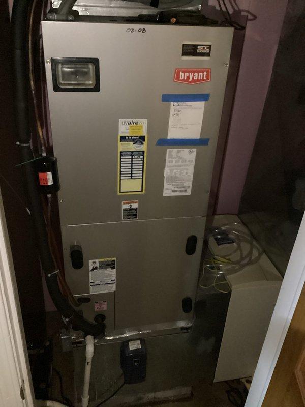 Responded to service call for water leakage from under HVAC air handler unit. Upon inspection, located Bryant air handler in utility closet and identified water discharge issue at base of unit near condensate drain lines. Inspected PVC condensate drainage system, cleared blockage, and verified proper drainage flow to resolve water leakage problem.