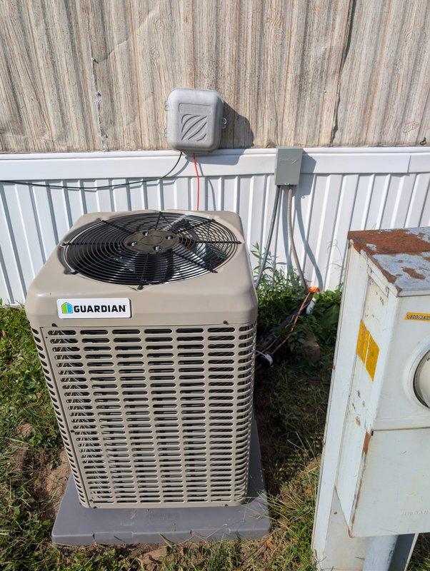 Completed installation of new Guardian brand air conditioning condenser unit and evaporator coil system, replacing heavily deteriorated existing equipment that exhibited significant rust and corrosion. Mounted new condenser on composite pad in backyard location, installed electrical disconnects on exterior wall with proper conduit runs, and established all necessary refrigerant line connections. Verified system operation with supply air temperature reading of 100°F at register, confirming proper airflow and system startup.