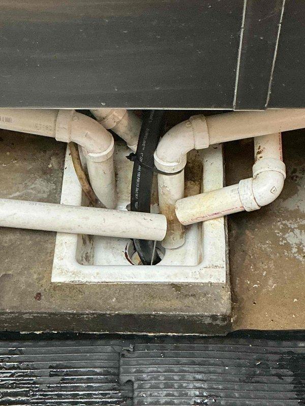 Responded to commercial facility for clogged floor drain beneath utility sink. Successfully cleared obstruction in floor drain using appropriate drain cleaning equipment. Verified proper drainage flow through PVC drain assembly and confirmed all connections were functioning correctly upon completion.