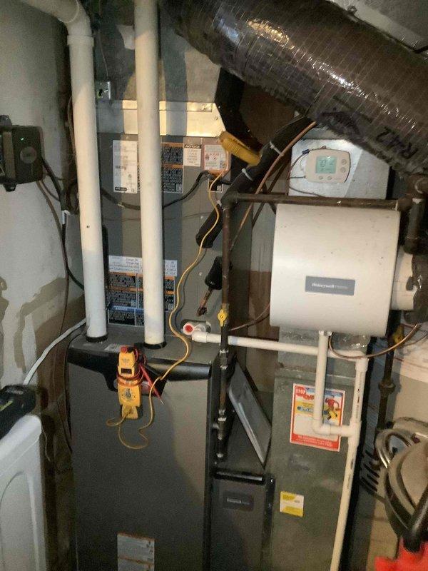 Completed comprehensive maintenance service on residential HVAC system including furnace and air handler with humidification equipment. Performed thorough inspection of all system components, verifying proper operation of heating and cooling equipment. Inspected electrical connections at panel and verified voltage readings within manufacturer specifications. Examined refrigerant lines and insulation for integrity, confirmed proper routing and connections between units. Checked condensate drain lines and PVC venting for proper flow and clearances. Verified ductwork connections and flexible duct routing. Inspected Honeywell thermostat operation, confirmed accurate temperature reading and proper system communication. Replaced 20x25x4 air filter as part of routine maintenance protocol. Documented system condition with photographic records showing equipment configuration and installation status. All components operating within normal parameters upon completion of maintenance service.