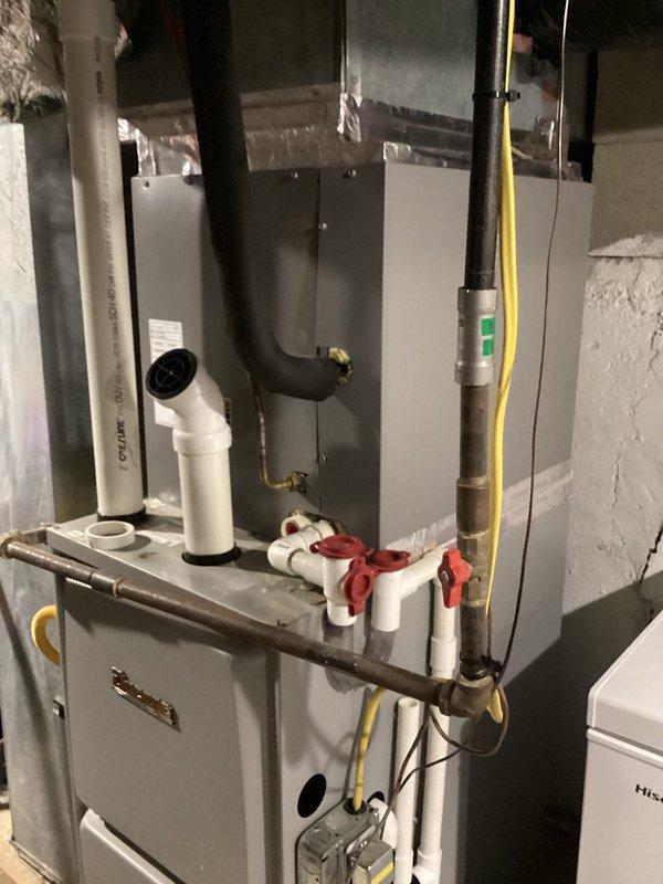 Responded to customer inquiries regarding HVAC system operation and thermostat functionality. Documented current system configuration showing digital thermostat set to 67°F with proper operation and basement furnace installation with gas line, PVC condensate drainage, and ductwork connections all in satisfactory working condition.