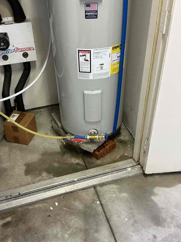 # Plumbing Install - Tanked Water Heater

Replaced existing 50-gallon electric water heater with new unit in residential utility closet. Disconnected electrical supply and plumbing connections from old water heater, then removed unit from service location. Positioned new water heater on elevated base for proper installation height and code compliance. Connected incoming cold water supply line and outgoing hot water distribution line using appropriate copper piping and brass fittings. Installed temperature and pressure relief valve with discharge pipe extension. Secured all plumbing connections and verified proper valve operation, including red-handled shutoff valve for system isolation. Reconnected electrical supply to unit per manufacturer specifications. Tested water heater operation, checked for leaks at all connection points, and verified proper heating function. Installation completed with all safety labels and energy guide information visible and accessible for future reference.