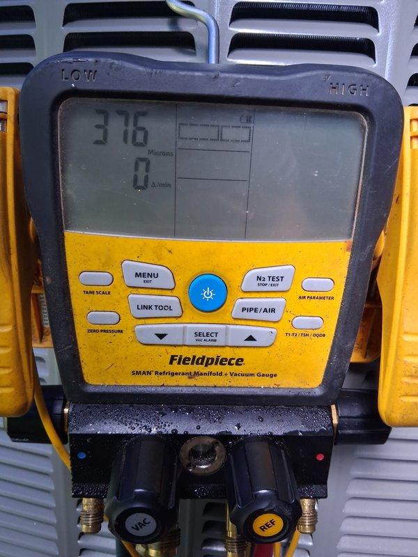 Completed warranty service on high-side refrigerant system. Performed diagnostic testing using refrigerant manifold gauge, verified system pressures, and conducted vacuum measurements showing 376 microns. Confirmed proper combustion operation with flame temperature reading of 27.2°F and ensured all components functioning within manufacturer specifications.