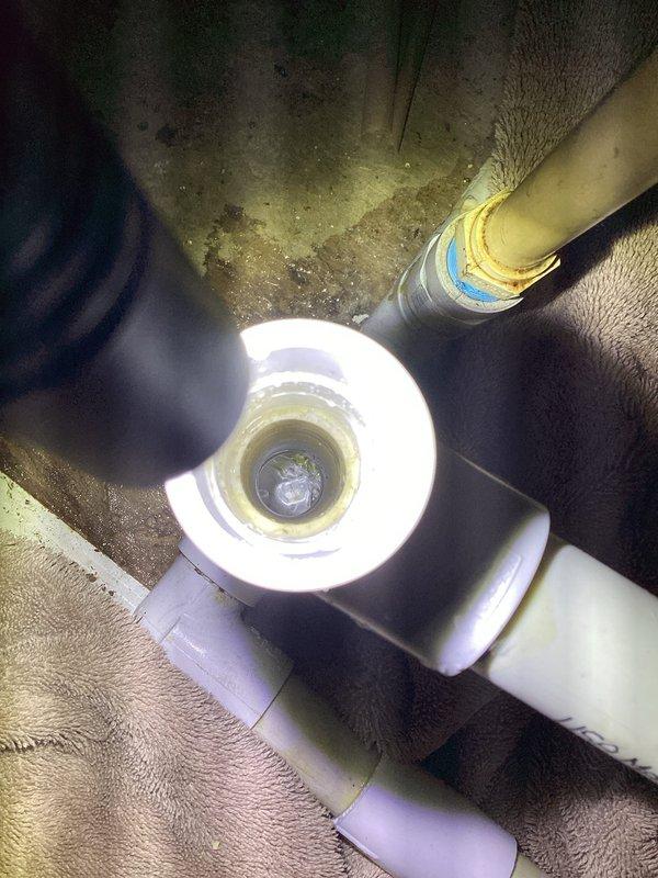 Responded to emergency no-cooling call for 1.5-year-old Lennox ML14KC1 system that had been previously shut down by fire department due to burning plastic smell. Upon arrival, confirmed clogged condensate drain line causing water leakage. Cleared drain line obstruction and verified proper drainage flow through PVC condensate system. Inspected all electrical connections and components for signs of overheating or damage related to previous burning smell complaint. Tested system operation and confirmed unit cooling properly with no unusual odors detected. Documented drain line configuration and connections with photos for service records.