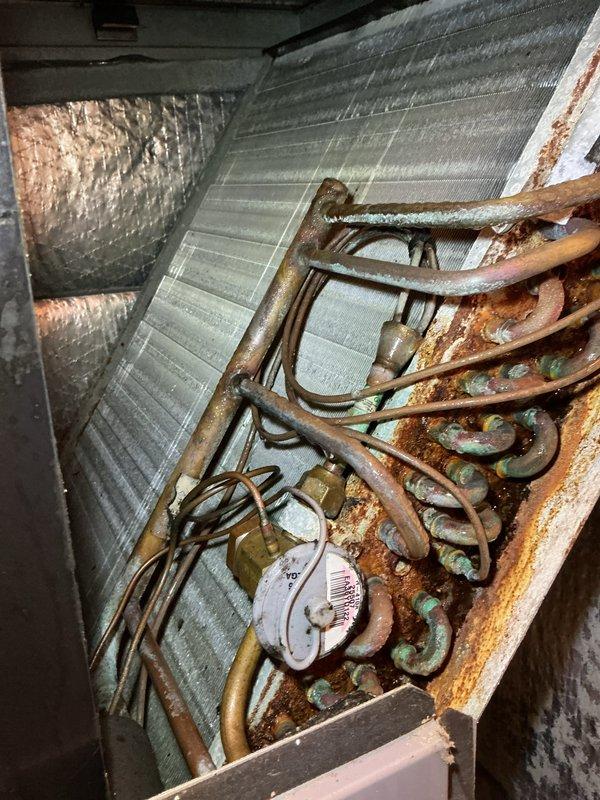 Completed annual spring maintenance visit on HVAC system under CCH basic plan. Inspection revealed extensive rust and corrosion on evaporator coil and refrigerant lines, with heavy oxidation deposits throughout the serpentine coil assembly. Performed electrical diagnostics using digital multimeter, recording voltage readings of 584V and 146V on system components. Documented current system condition with photographs showing significant deterioration of copper piping and coil assembly, indicating potential refrigerant leak concerns and reduced heat transfer efficiency. System requires 16x20x4 filter replacement by customer as filters are not included in basic maintenance plan. Equipment operational at time of service but recommended monitoring for performance decline due to advanced coil corrosion. Plan coverage extends through 10/5/26.