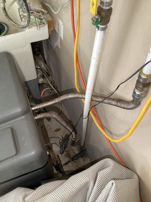 Responded to service call regarding excessive lime buildup on water heater system. Upon arrival, conducted thorough inspection of the tanked water heater and surrounding plumbing infrastructure. Documented existing conditions including water treatment equipment, filtration system with blue canister filter, water softener unit, and associated PVC piping and gas lines. Assessed lime scale accumulation on water heater components and evaluated overall system performance. Provided customer with recommendations for descaling treatment options and discussed maintenance procedures to prevent future mineral buildup. Photographed installation for service records.